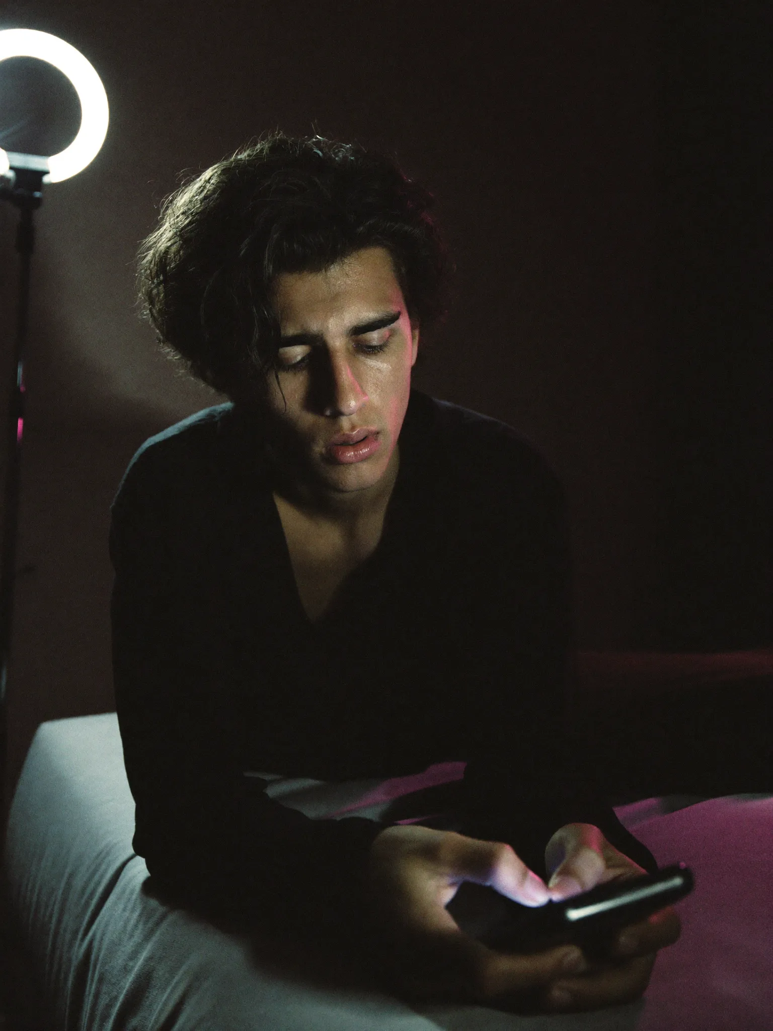 Creator exausto olhando o celular à noite, sem saber o que vende